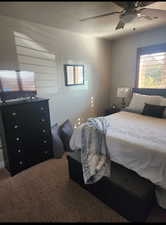 Carpeted bedroom featuring a ceiling fan