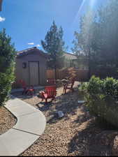 View of yard with a shed, fence, and an outdoor structure