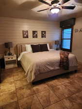 Tiled bedroom featuring a ceiling fan