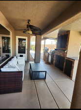 View of patio with an outdoor kitchen, grilling area, an outdoor living space, and ceiling fan