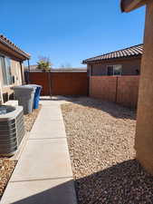 View of yard featuring a patio area, cooling unit, and fence