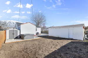 View of yard featuring a shed, a mountain view, a fenced backyard, and an outdoor structure