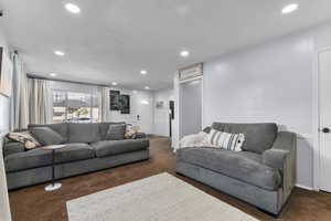 Living area with recessed lighting and dark carpet