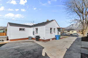 Rear view of house featuring a patio area, fence, and a mountain view