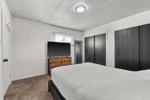 Carpeted bedroom featuring baseboards and multiple closets