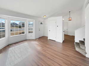 Interior space with baseboards, stairs, visible vents, and wood finished floors