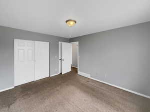 Unfurnished bedroom featuring baseboards, a closet, visible vents, and carpet flooring