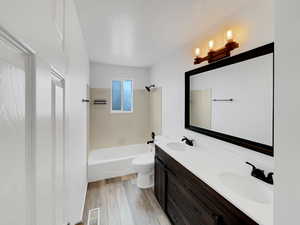 Full bath featuring toilet, double vanity, a sink, and visible vents