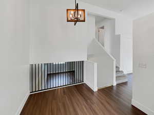 Interior space with baseboards, stairway, and wood finished floors