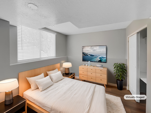 Bedroom with a textured ceiling, wood finished floors, and baseboards