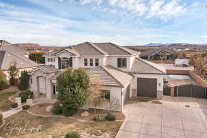 View of front of home featuring a garage, concrete driveway, stone siding, a gate, and stucco siding