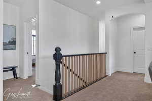 Hall with carpet floors, recessed lighting, baseboards, and an upstairs landing