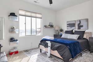 Bedroom with baseboards, visible vents, and ceiling fan