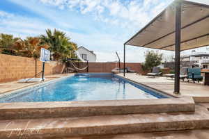 View of pool with a patio area, a fenced backyard, and a fenced in pool