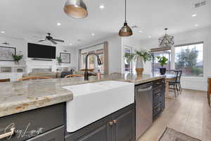 Kitchen featuring stainless steel dishwasher, a sink, visible vents, and decorative light fixtures