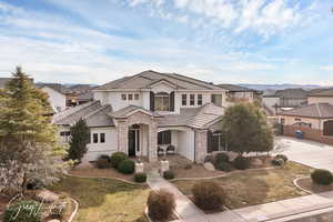 View of front of home with a tile roof, driveway, fence, and stucco siding