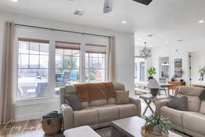 Living room with a ceiling fan, visible vents, wood finished floors, and recessed lighting