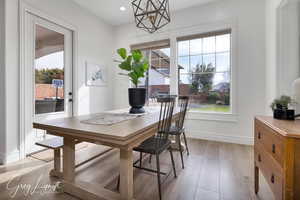 Dining area featuring light wood-style floors, baseboards, an inviting chandelier, and recessed lighting