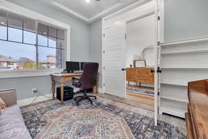 Office space with baseboards and a tray ceiling