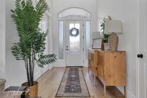 Entrance foyer featuring baseboards and light wood-style floors