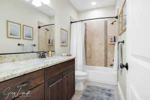 Full bathroom featuring shower / bath combo, tile patterned flooring, vanity, and toilet