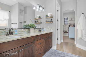 Bathroom featuring wood finished floors, a sink, and a healthy amount of sunlight