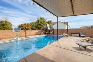 View of pool with a patio area, a fenced backyard, a fenced in pool, and a water slide