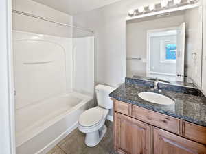 Full bath with tile patterned flooring, toilet, vanity, visible vents, and shower / washtub combination