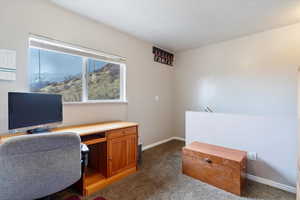 Office space featuring baseboards and dark carpet