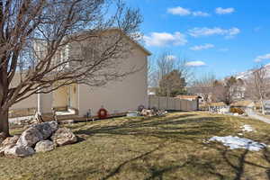 View of side of property featuring a yard and fence