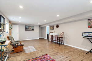 Living area with light wood finished floors, recessed lighting, and baseboards