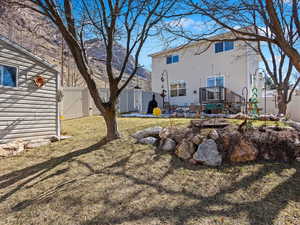 Back of property featuring a gate, a fenced backyard, a lawn, and a deck