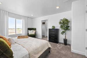 Bedroom featuring baseboards, visible vents, carpet, a textured ceiling, and recessed lighting