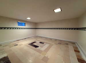 Bedroom featuring wallpapered walls, baseboards, and tile patterned floors