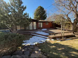 Rear view of property featuring a deck and brick siding