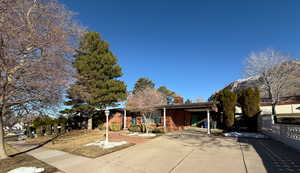 View of front of home featuring driveway and fence