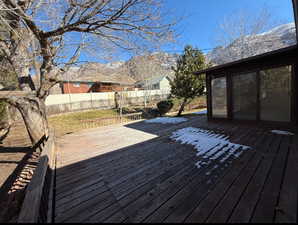 Wooden terrace featuring fully fenced yard and mountain views