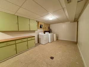 Washroom with light floors, washing machine and clothes dryer, cabinet space, visible vents, and baseboards