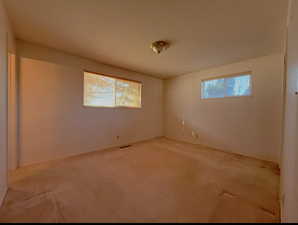 Master bedroom featuring a wealth of natural light and light colored carpet