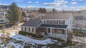 Traditional-style home with covered porch, a shingled roof, brick siding, and a mountain view