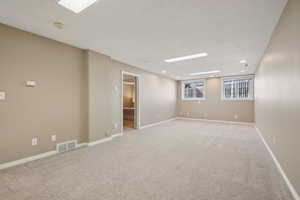 Spare room with light carpet, baseboards, visible vents, and recessed lighting