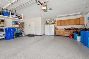 Garage featuring freestanding refrigerator and a garage door opener