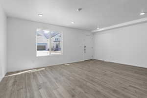 Unfurnished room with recessed lighting, a textured ceiling, baseboards, and wood finished floors