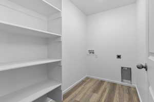 Laundry area featuring hookup for a washing machine, hookup for an electric dryer, wood finished floors, laundry area, and baseboards