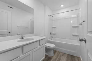 Full bathroom featuring visible vents, toilet, tub / shower combination, vanity, and wood finished floors