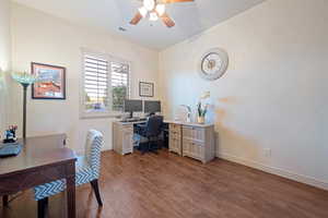 Home office featuring baseboards, visible vents, ceiling fan, and wood finished floors