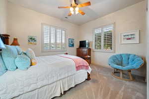 Bedroom with carpet floors, baseboards, visible vents, and ceiling fan