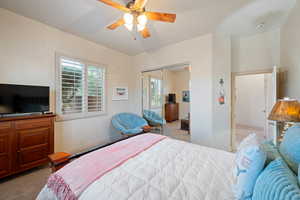 Bedroom featuring a ceiling fan, a closet, and light colored carpet