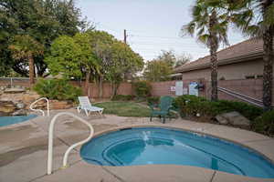 View of pool with a community hot tub, a patio area, and a fenced backyard