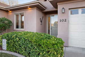 Property entrance with an attached garage and stucco siding